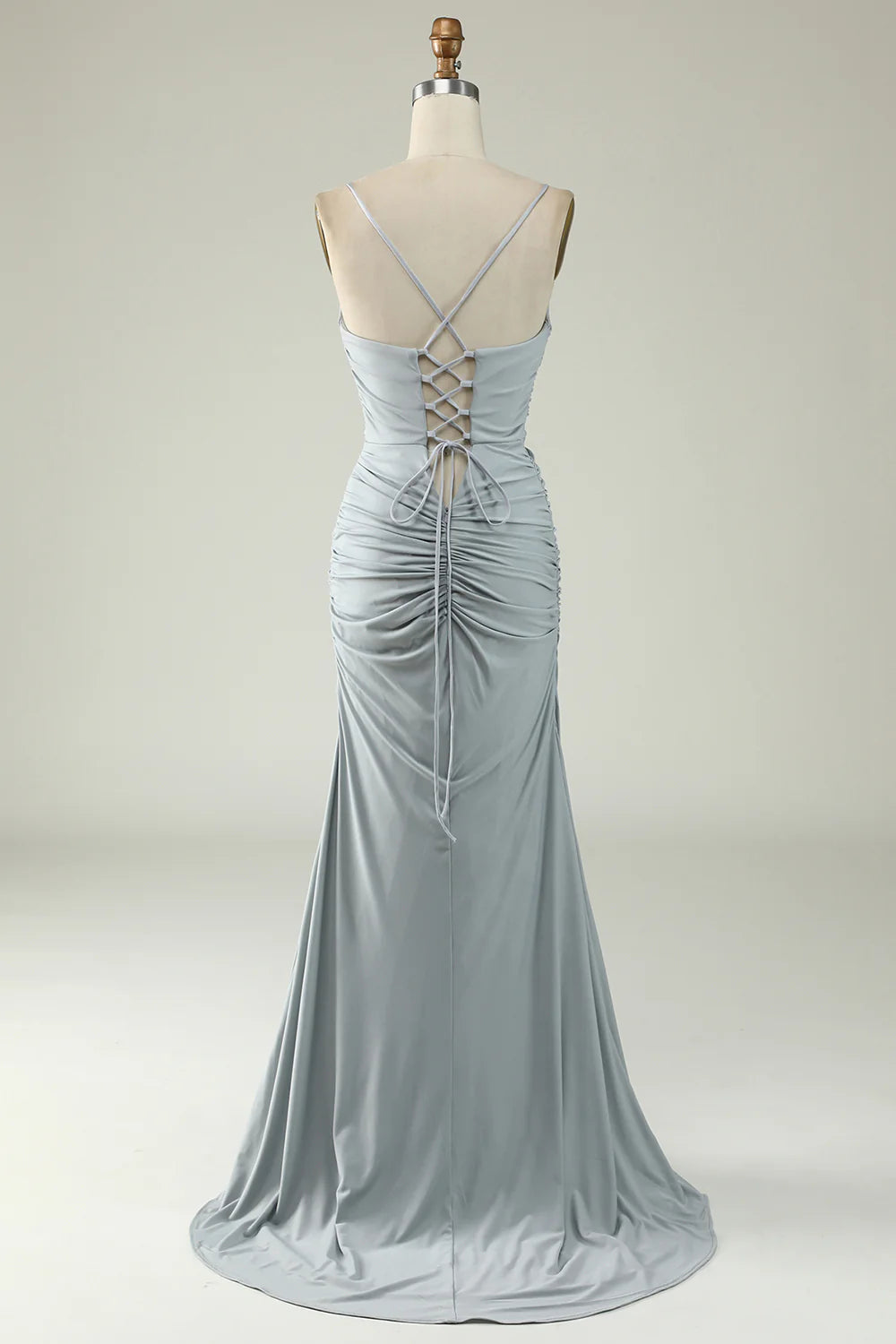 Woman posing in a grey mermaid prom dress, showing the back and side profile.