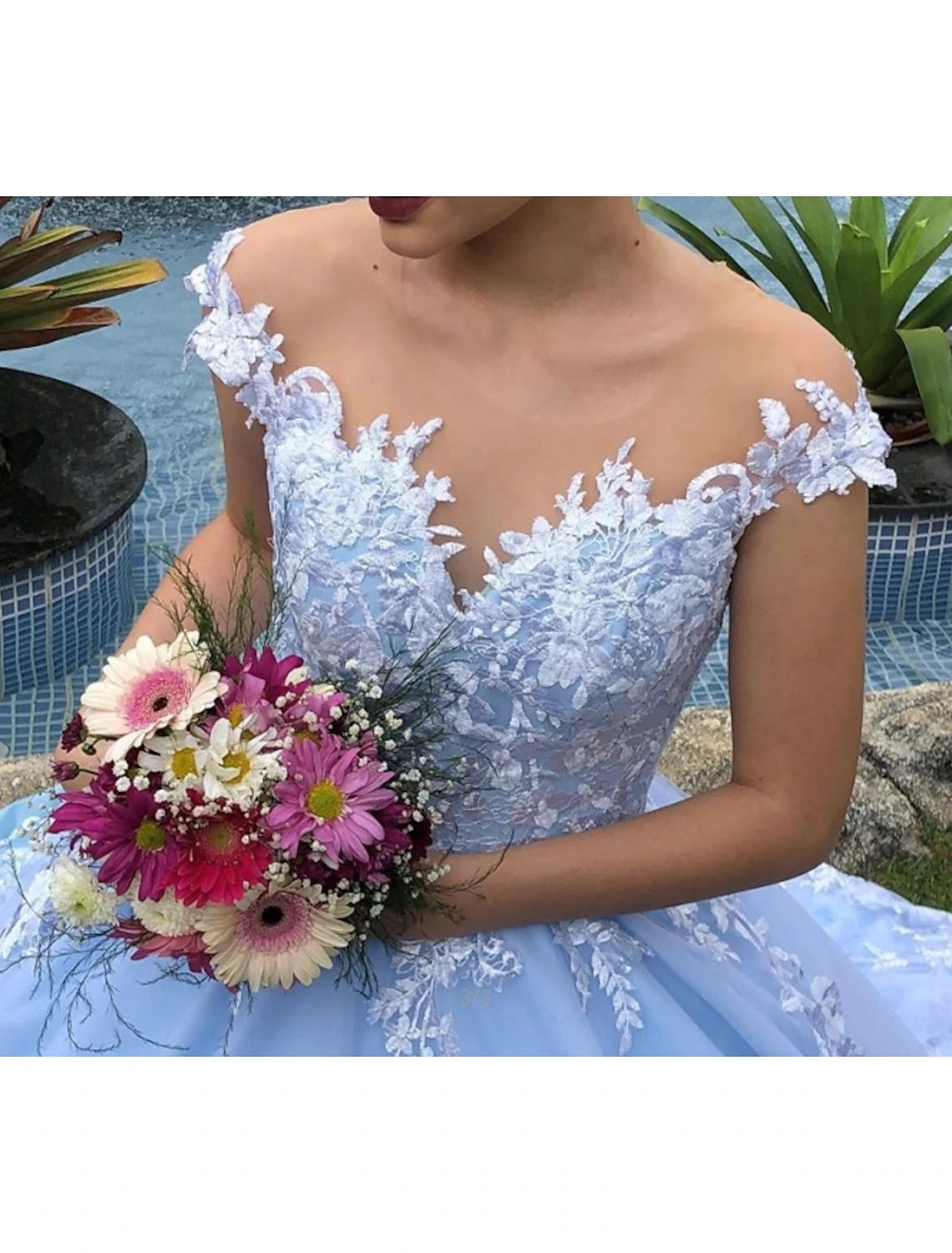 Side view of a bride wearing a cap sleeve ball gown with intricate lace details.