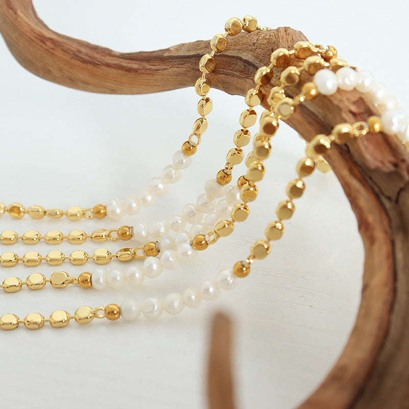 Close-up of freshwater pearls on a copper bracelet.