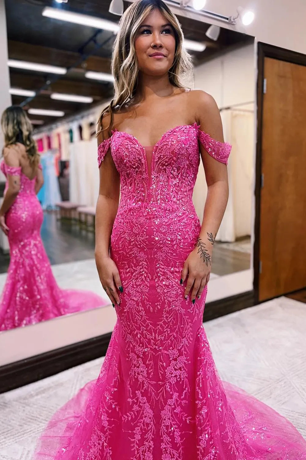 Long fuchsia prom dress featuring a mermaid silhouette, glitter fabric, and delicate appliques, back view.
