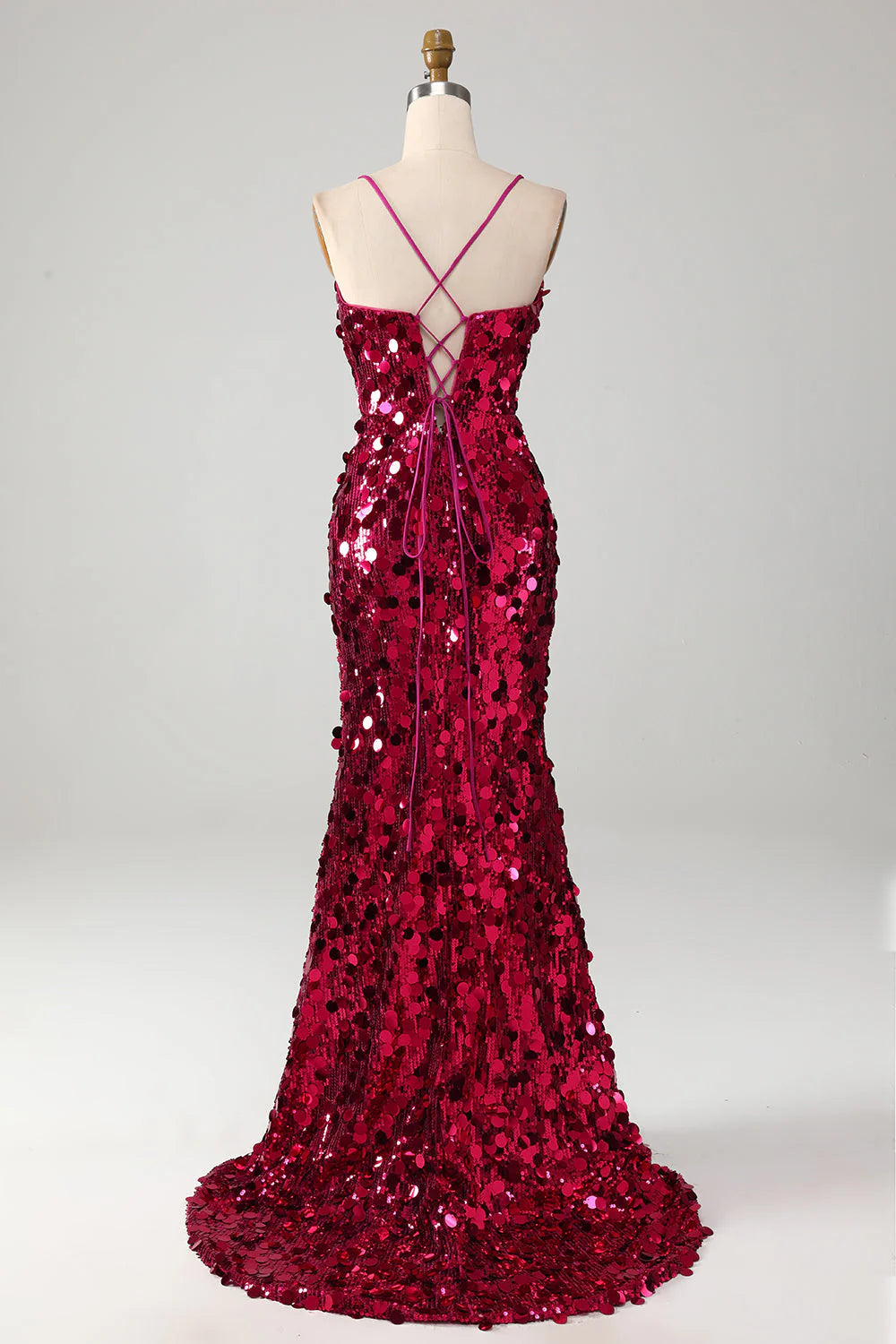 Side view of a woman wearing a fuchsia sequin mermaid dress, showcasing the elegant silhouette.