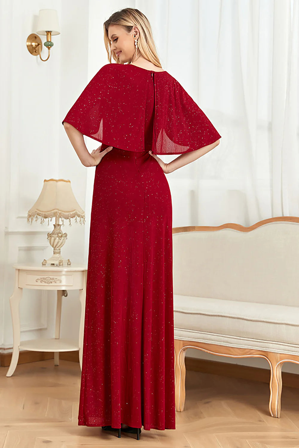 Close-up of the shimmering glitter fabric and delicate cape detail on the dress.