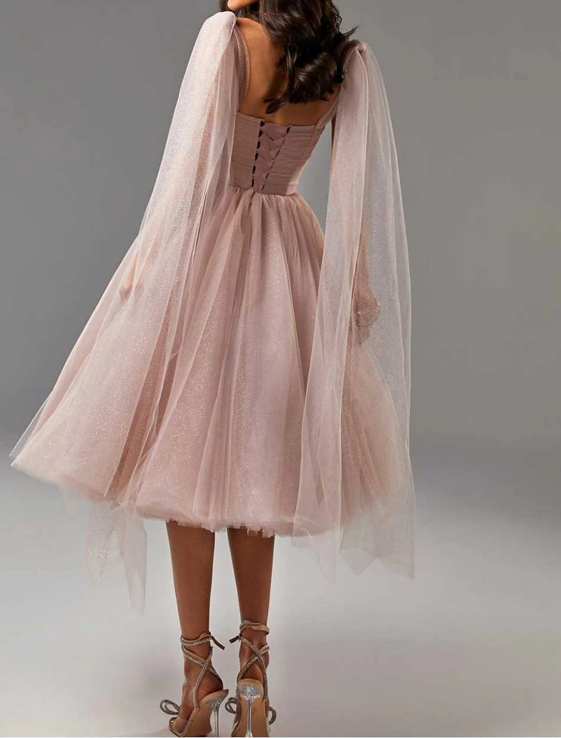 Side view of the tea-length glitter tulle dress, highlighting the corset detail.