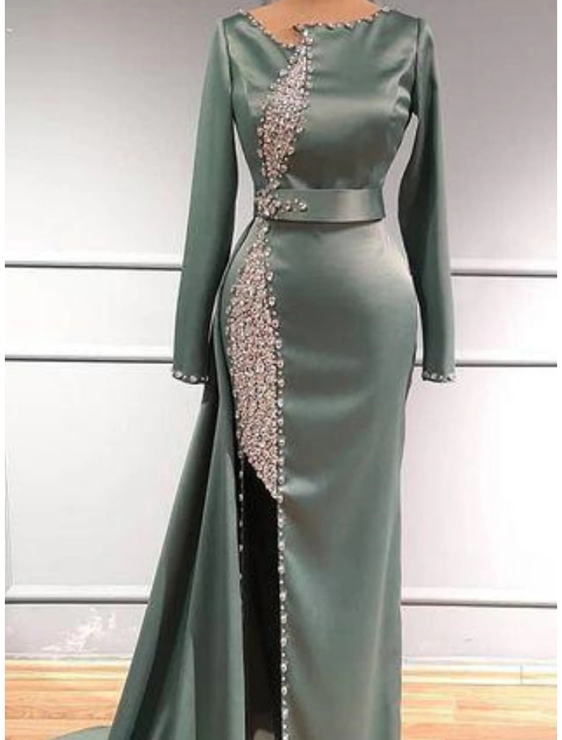 Elegant glittering sheath evening dress with jewel neck and long sleeves.