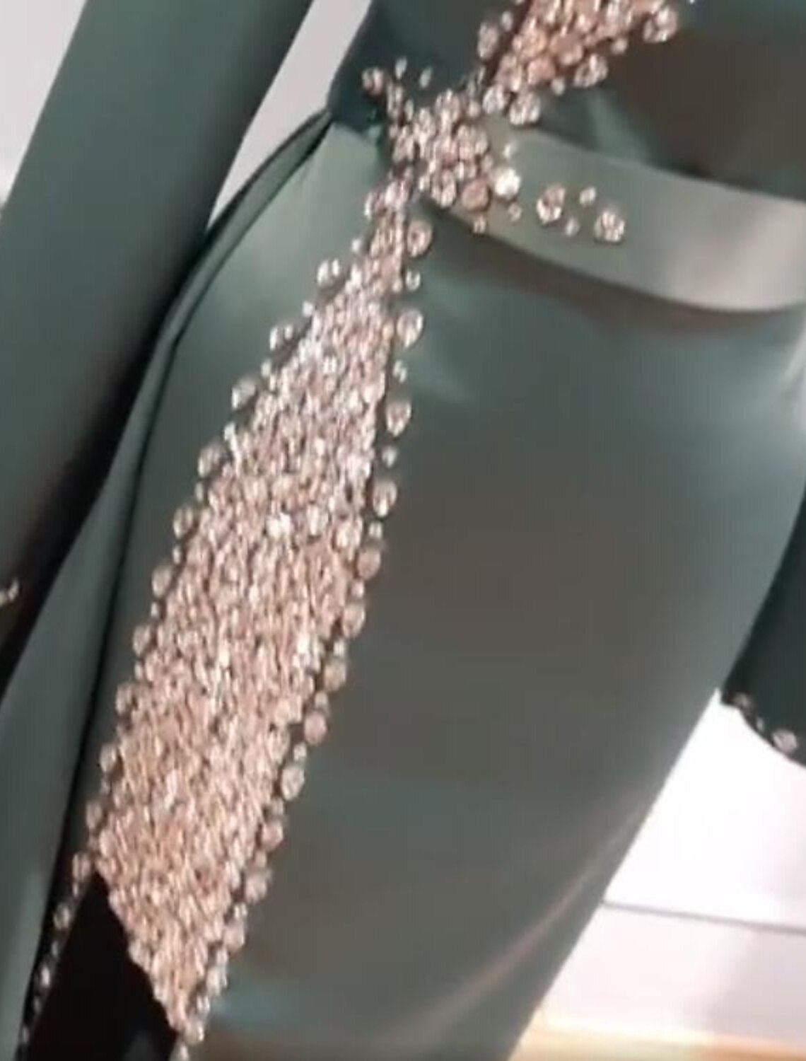 Close-up of the charmeuse fabric, glittering details, beading, and sequins.