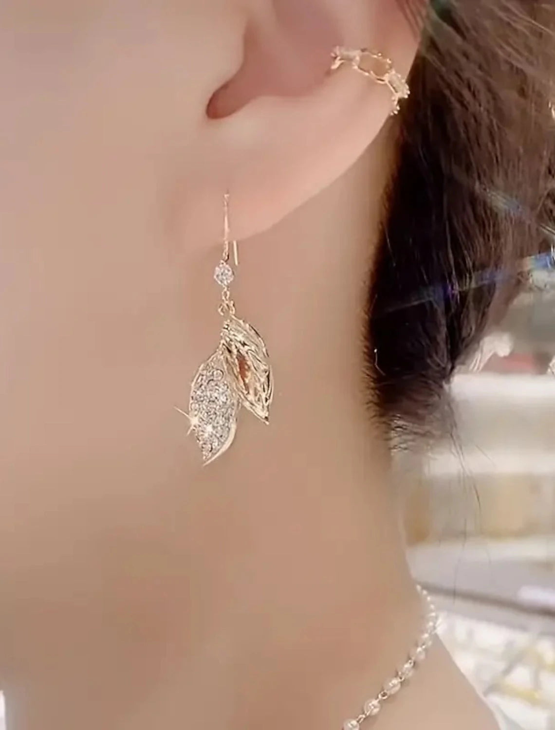 Gold leaf drop earring, side view showing intricate design.