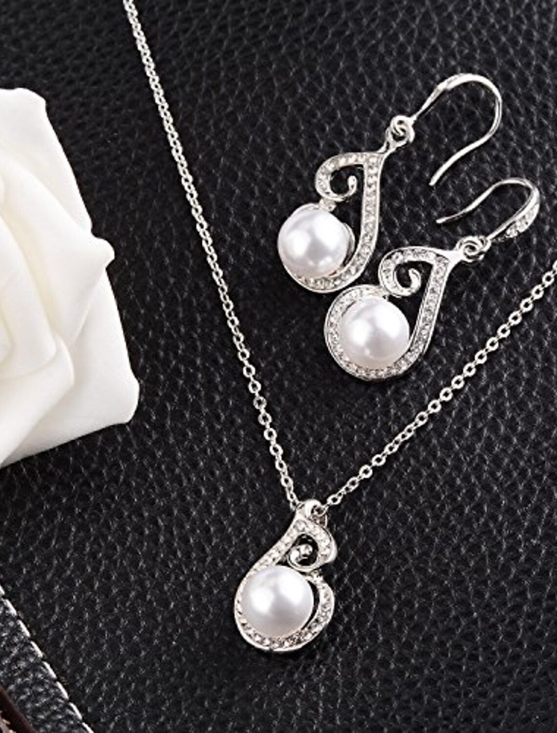Close-up of gold plated faux pearl jewelry set, including necklace and earrings.
