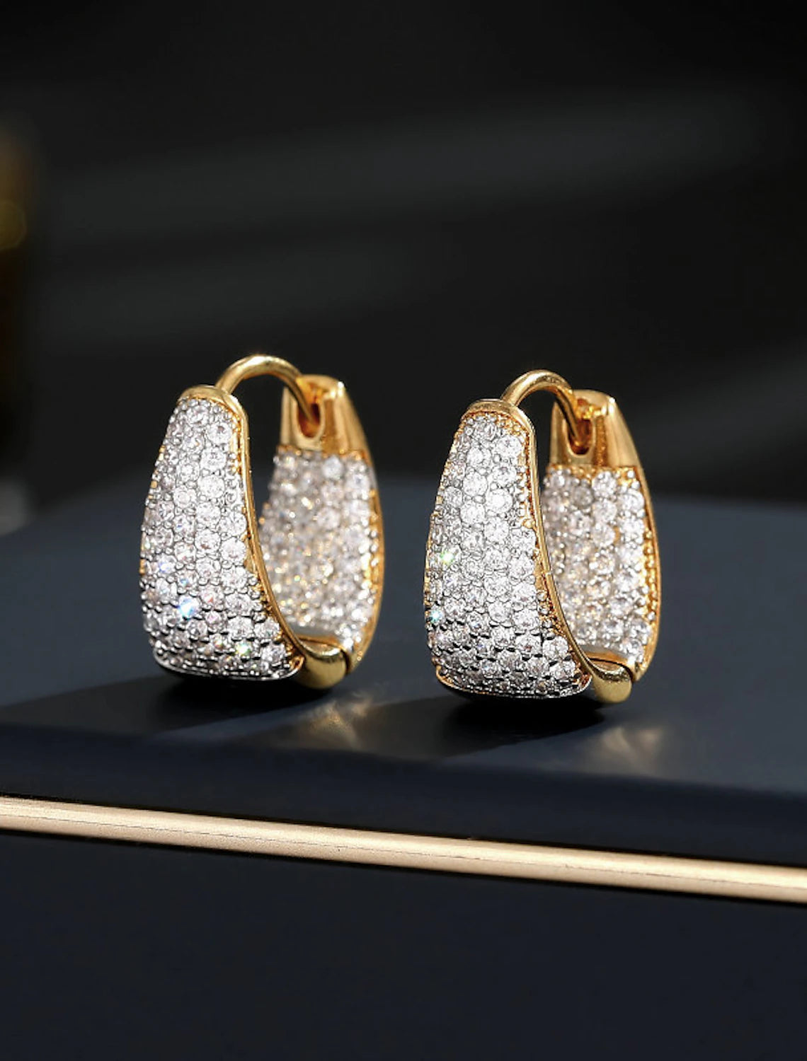 Close-up of a sparkling gold zircon hoop earring.