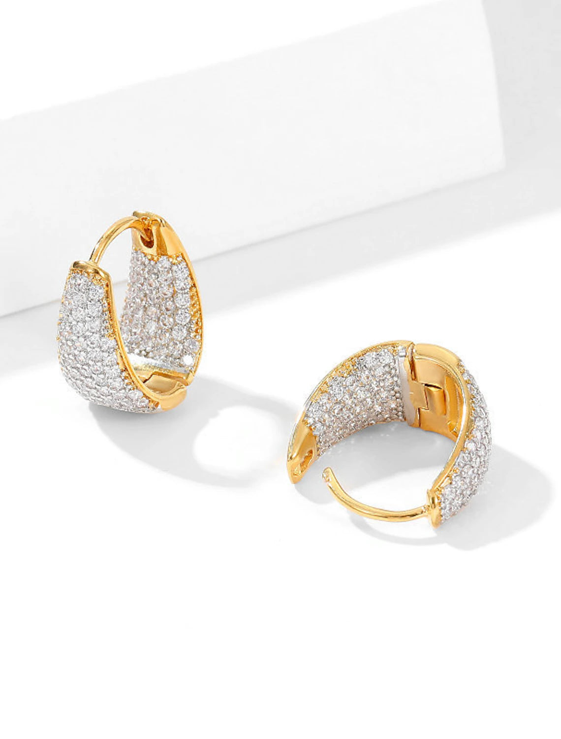 Side view of a gold zircon hoop earring.