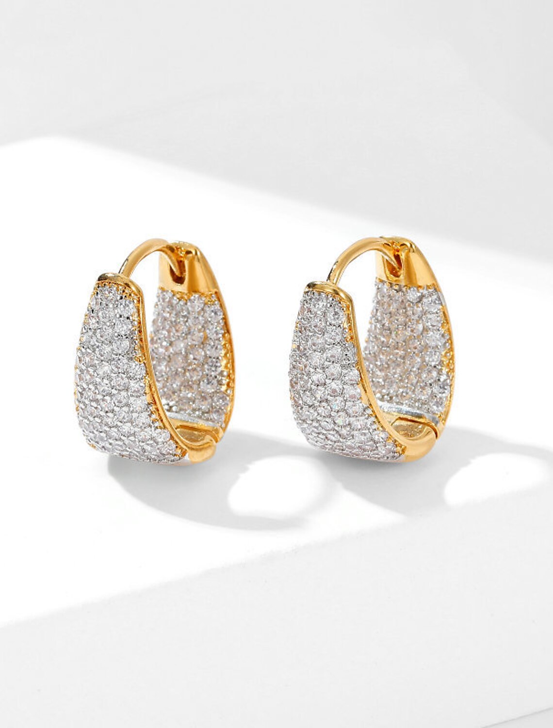 Detailed view of a gold zircon hoop earring's craftsmanship.