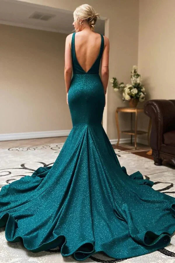 Model wearing a shiny green mermaid V-neck evening gown with a thigh-high slit.