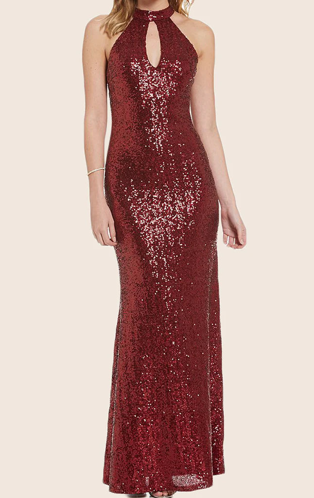 Woman wearing a sparkling halter sequin maxi formal gown with an open back.