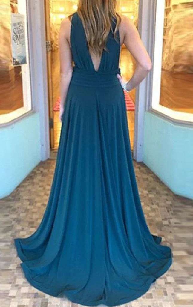 Model posing in a flowing halter deep V-neck formal gown.