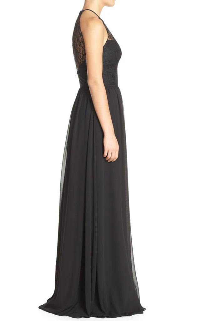 Side view of a woman modeling a long lace halter formal gown.