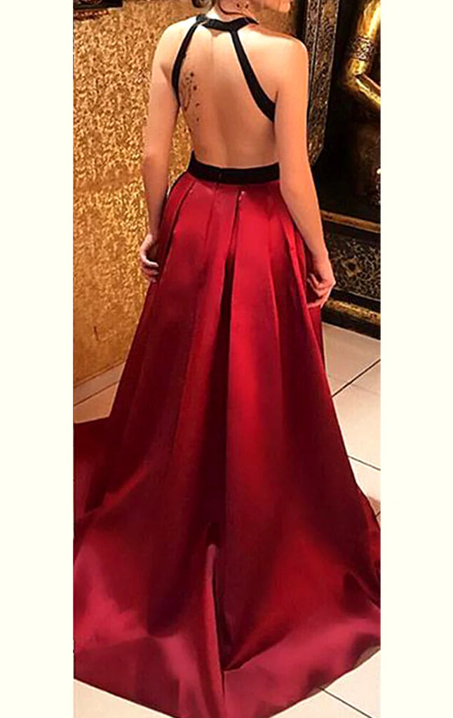 Back view of a woman in a sophisticated halter open back satin evening gown.