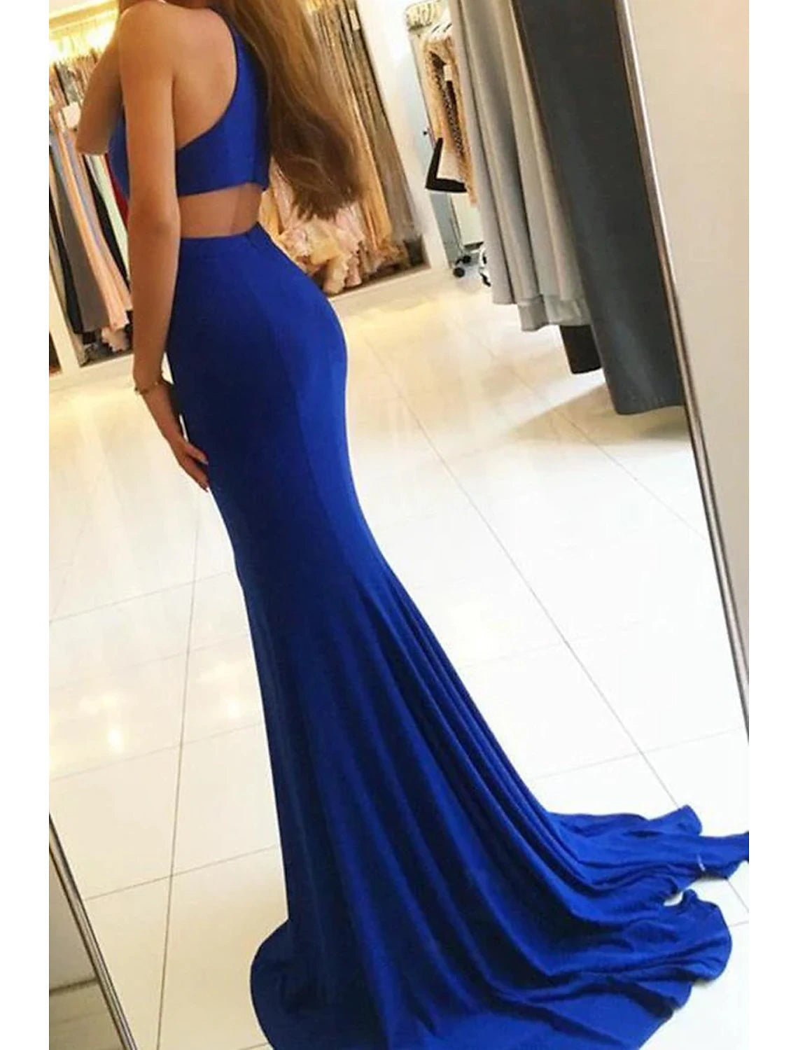 Model wearing a sleeveless high neck prom gown.