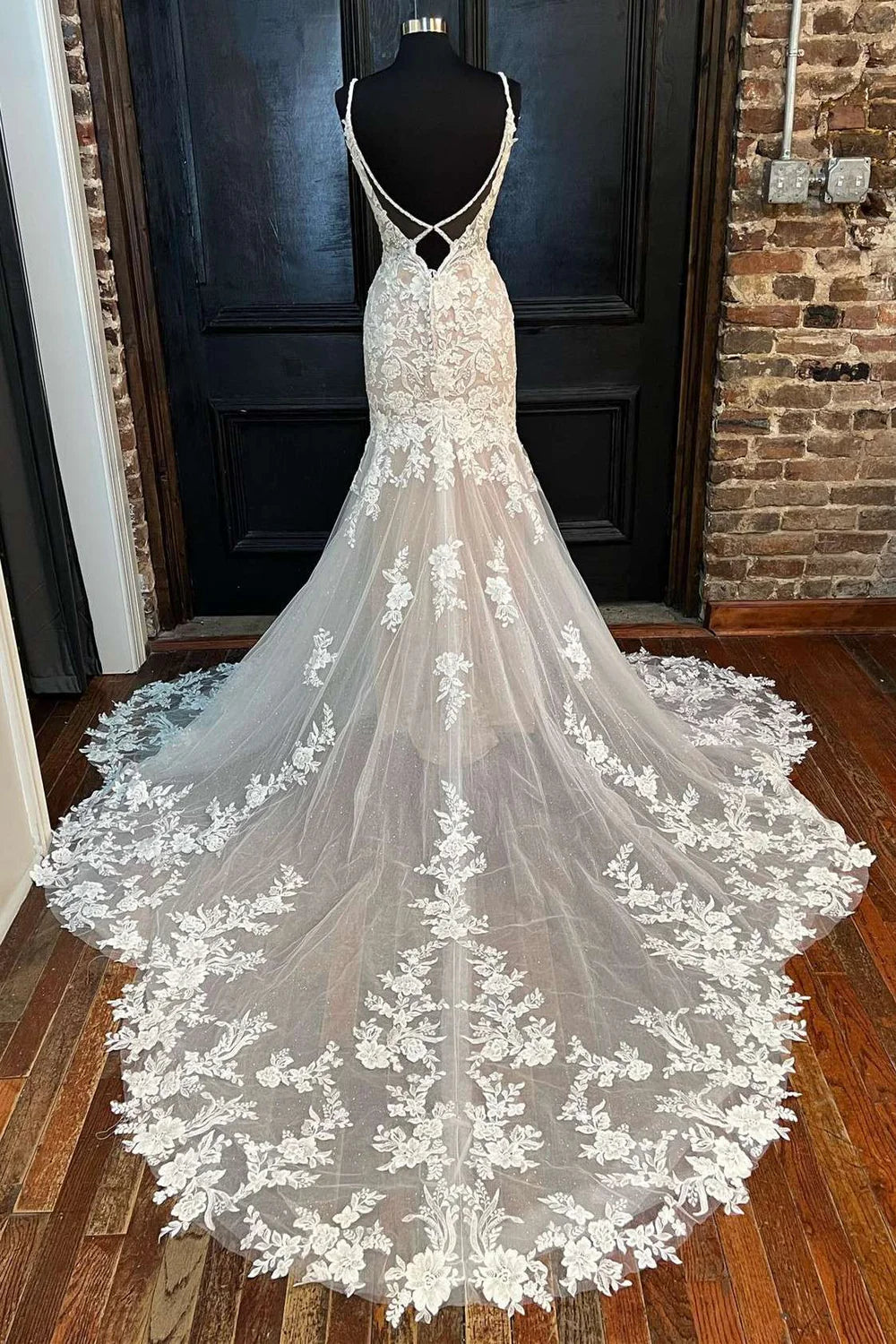 Back view of a white trumpet wedding dress showcasing its backless detail.