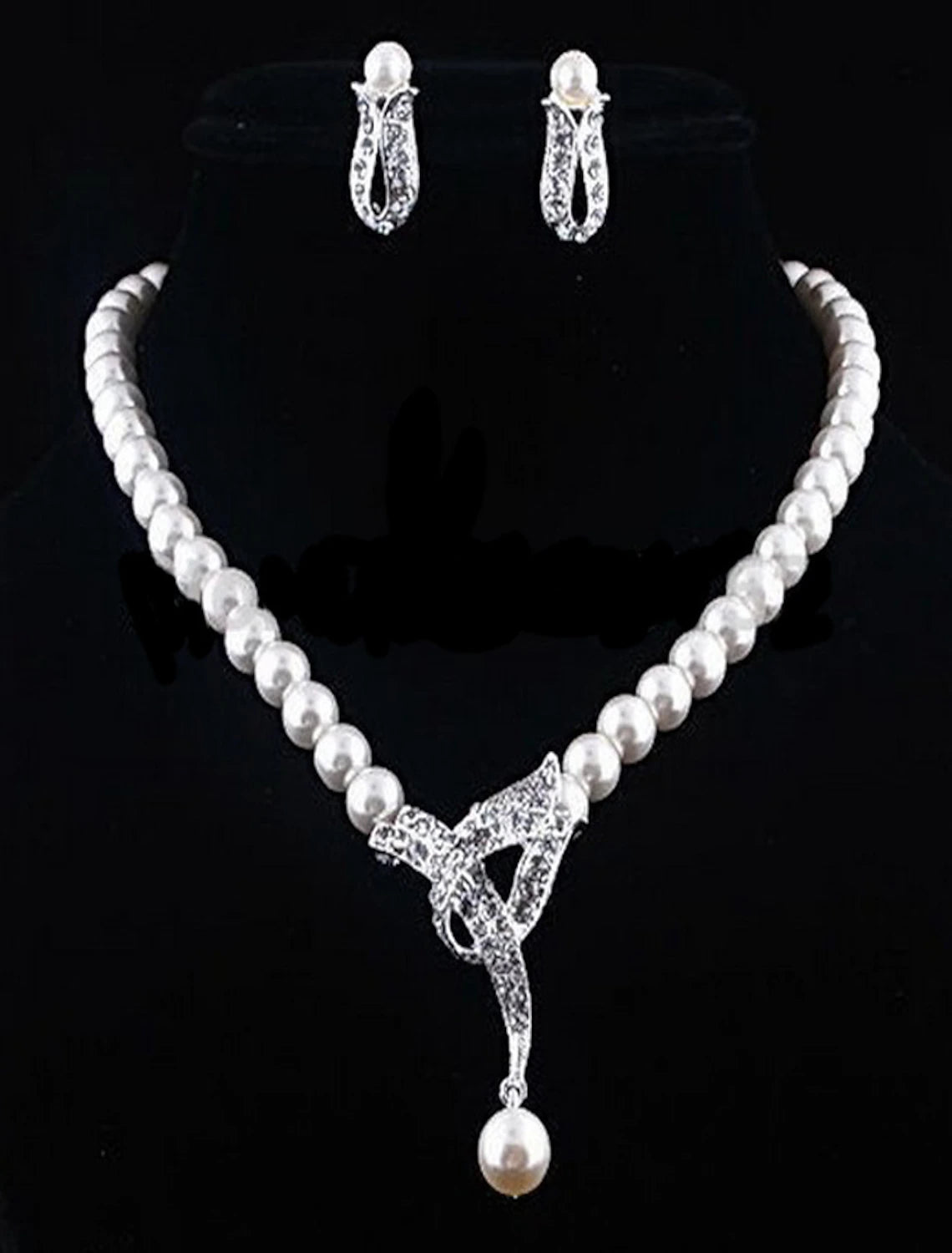 Close-up of imitation pearl and rhinestone earrings from the bridal set.