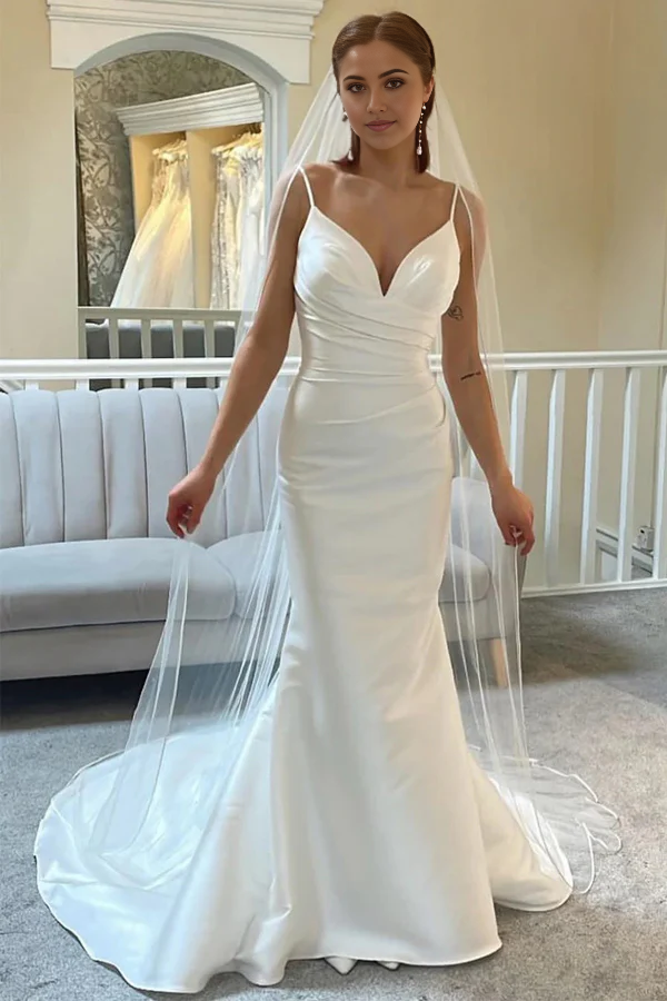 Elegant ivory mermaid trumpet wedding dress with spaghetti straps.