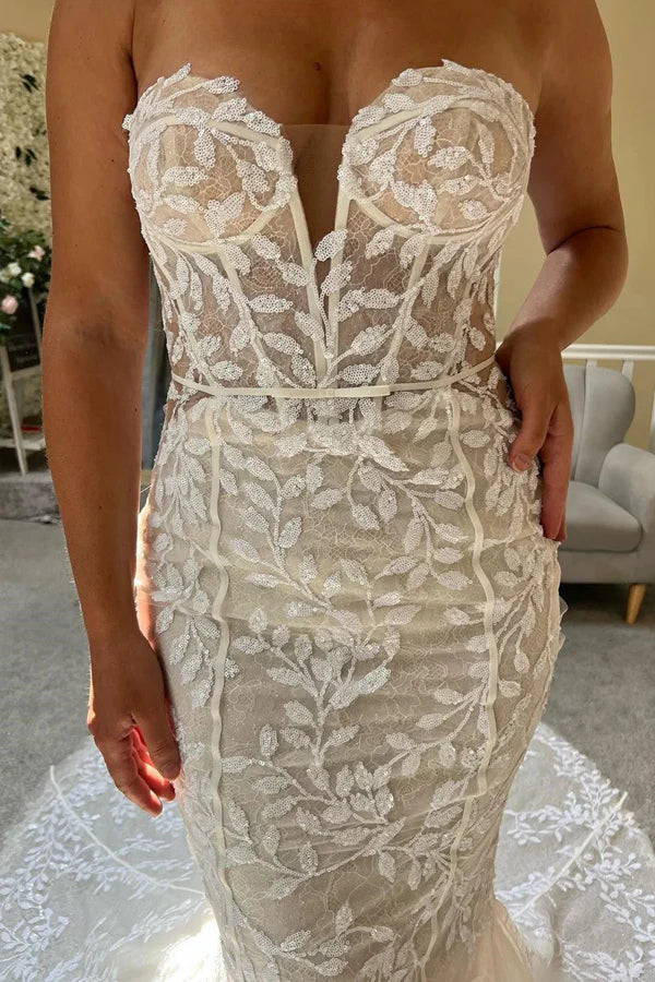 Back view of a strapless ivory lace wedding dress with intricate detailing.