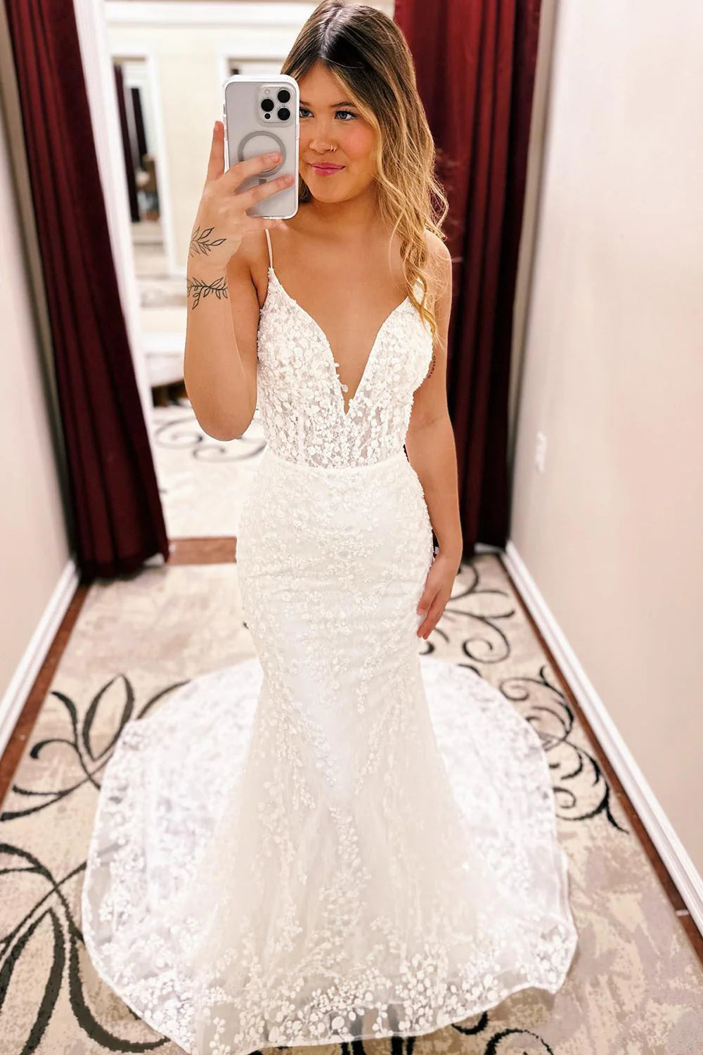 Elegant ivory mermaid wedding dress with spaghetti straps, intricate lace, and a long train.