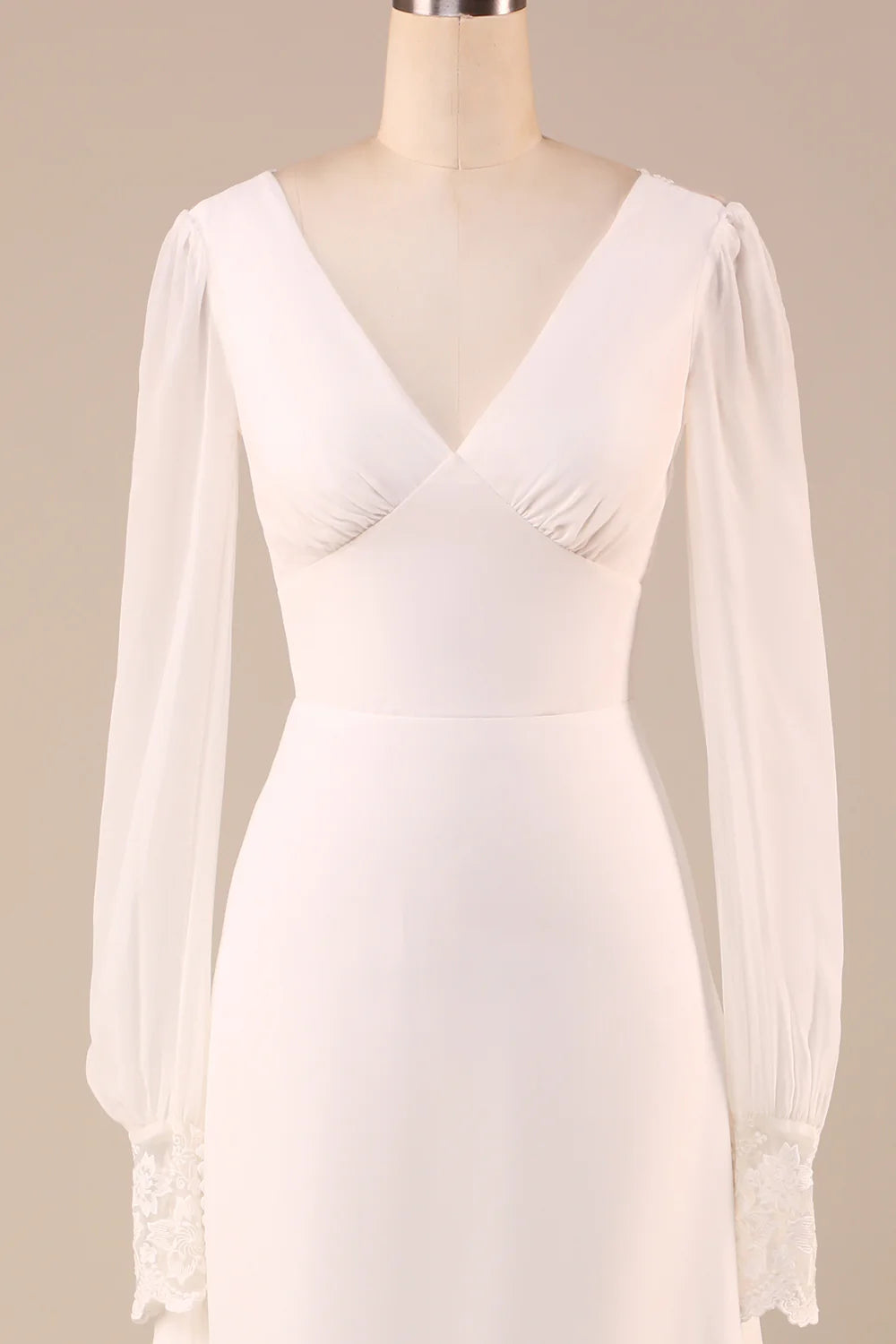 Side profile of an ivory mermaid wedding dress, showing long sleeves and fitted silhouette.
