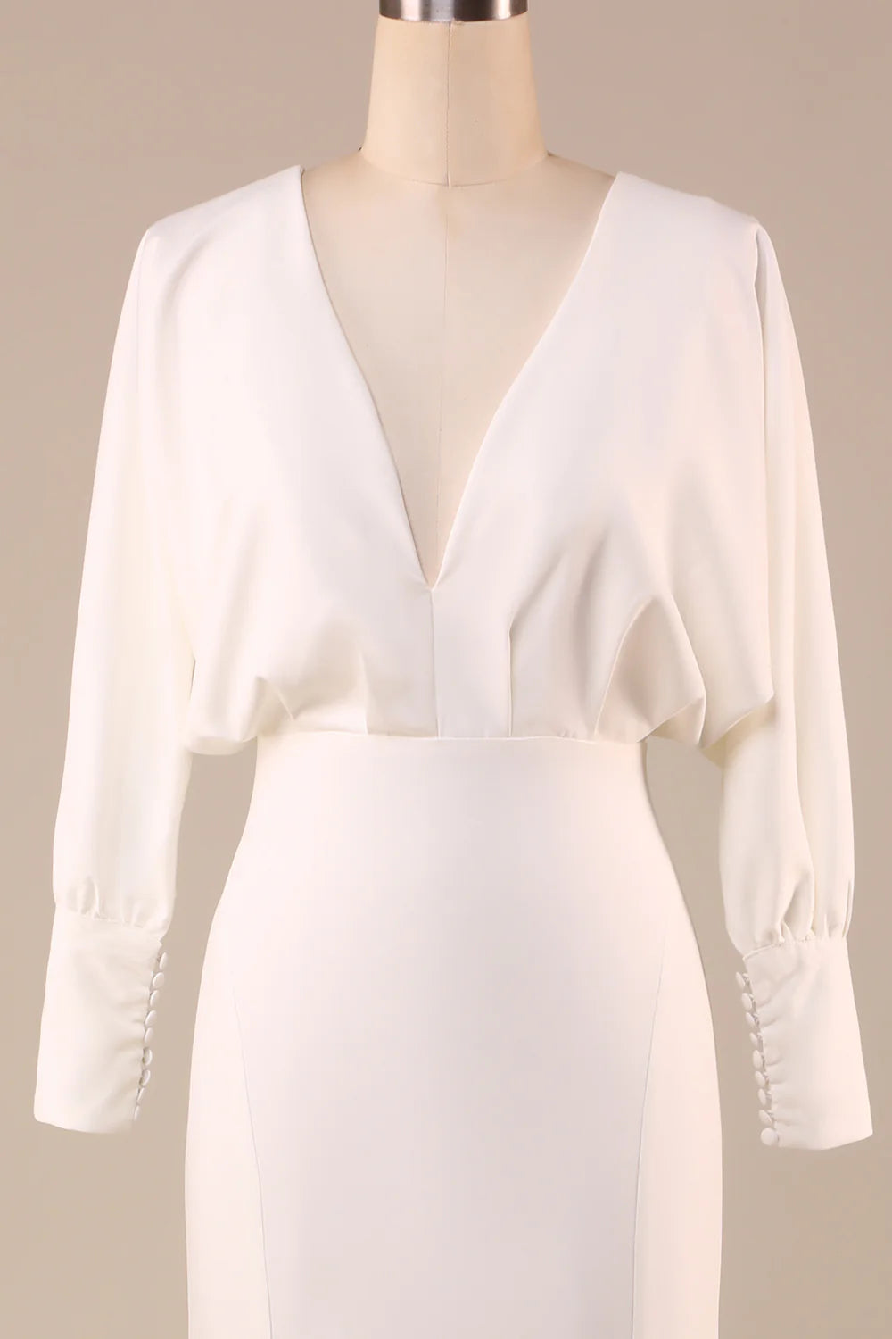 Side view of bride wearing ivory satin long sleeve wedding dress.