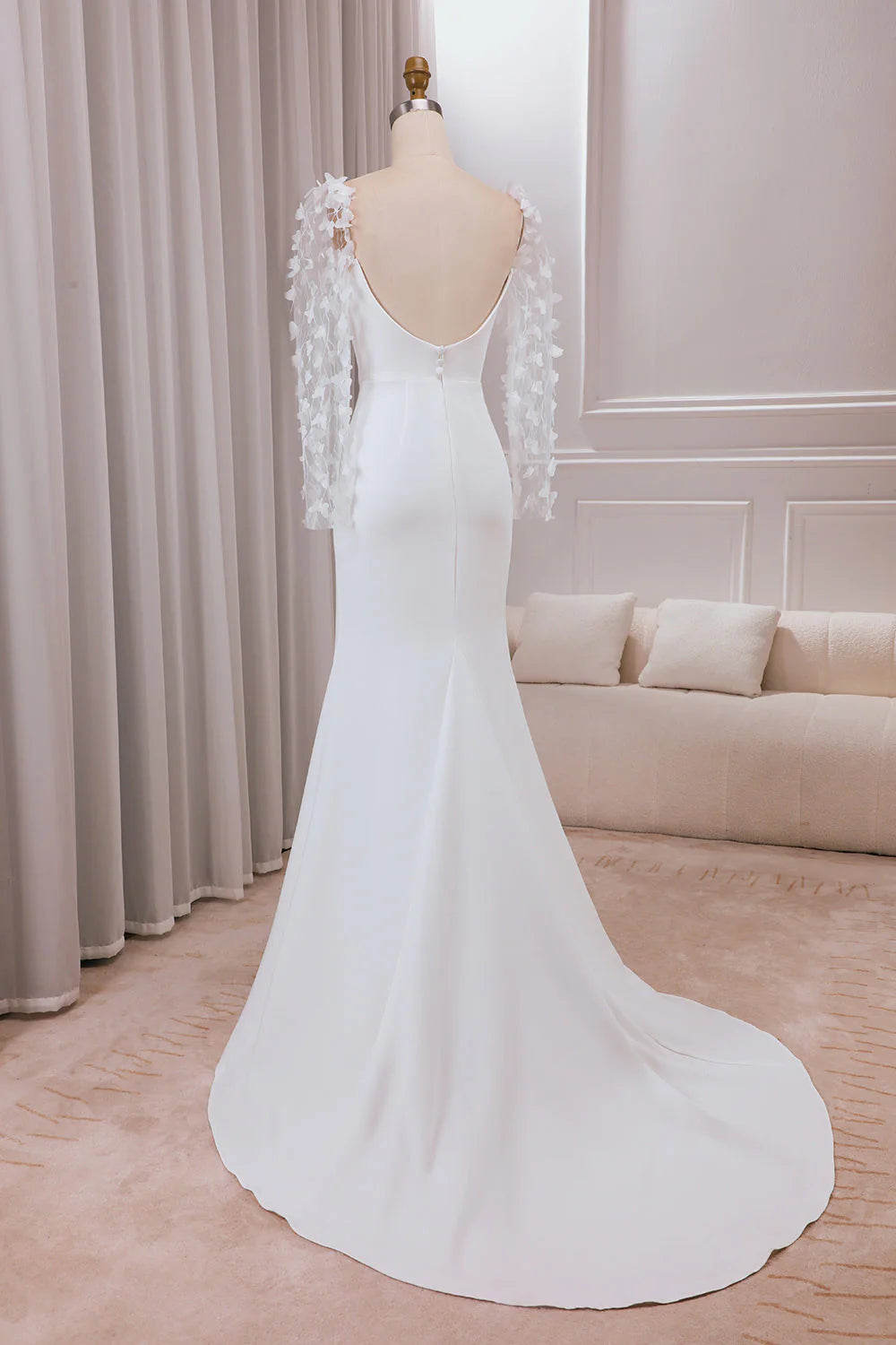 Back view of ivory trumpet wedding dress showing sweep train and appliques.