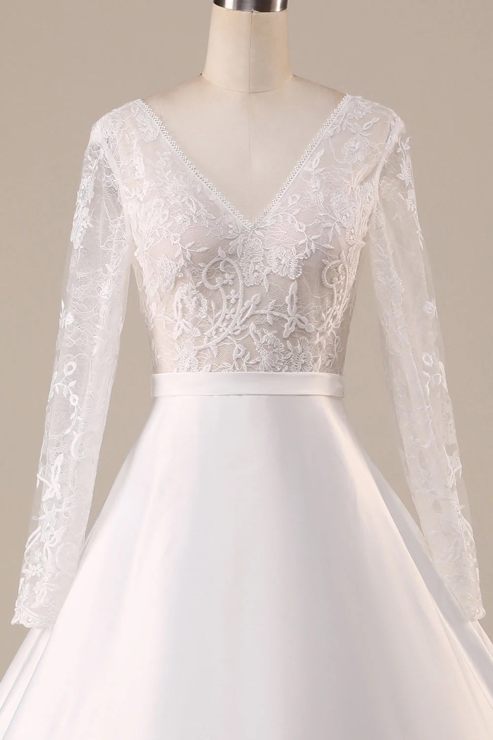 Side profile of a bride wearing an ivory satin long sleeve wedding dress.