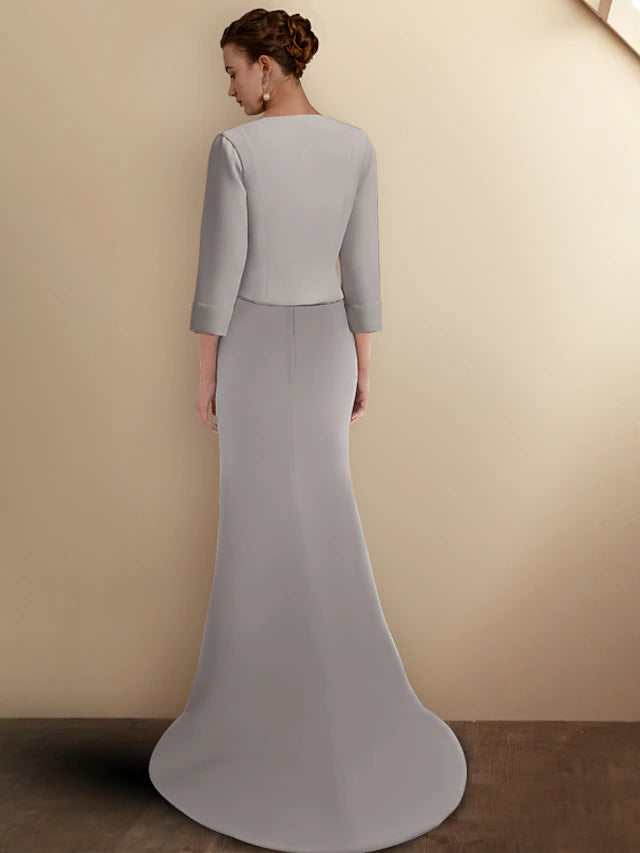 Woman posing gracefully in the elegant mermaid trumpet Mother of the Bride dress with its matching short jacket.