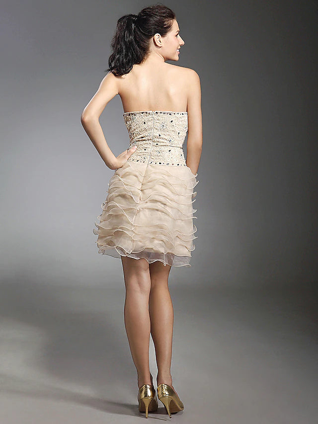 Model walking in the elegant short strapless lace and beaded dress.
