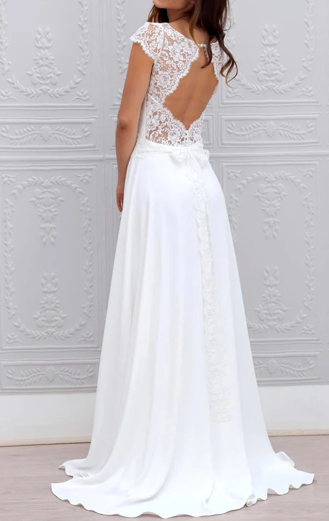 Side view of a woman in a flowing sleeveless lace and chiffon formal evening gown.