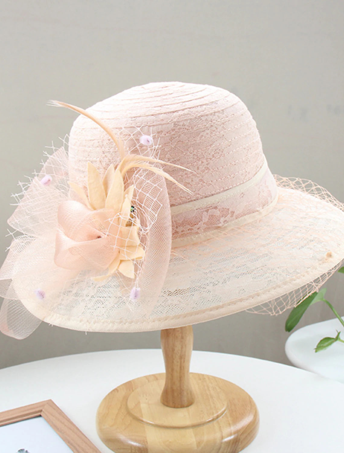 Side view of a woman wearing a formal lace and feather headpiece.