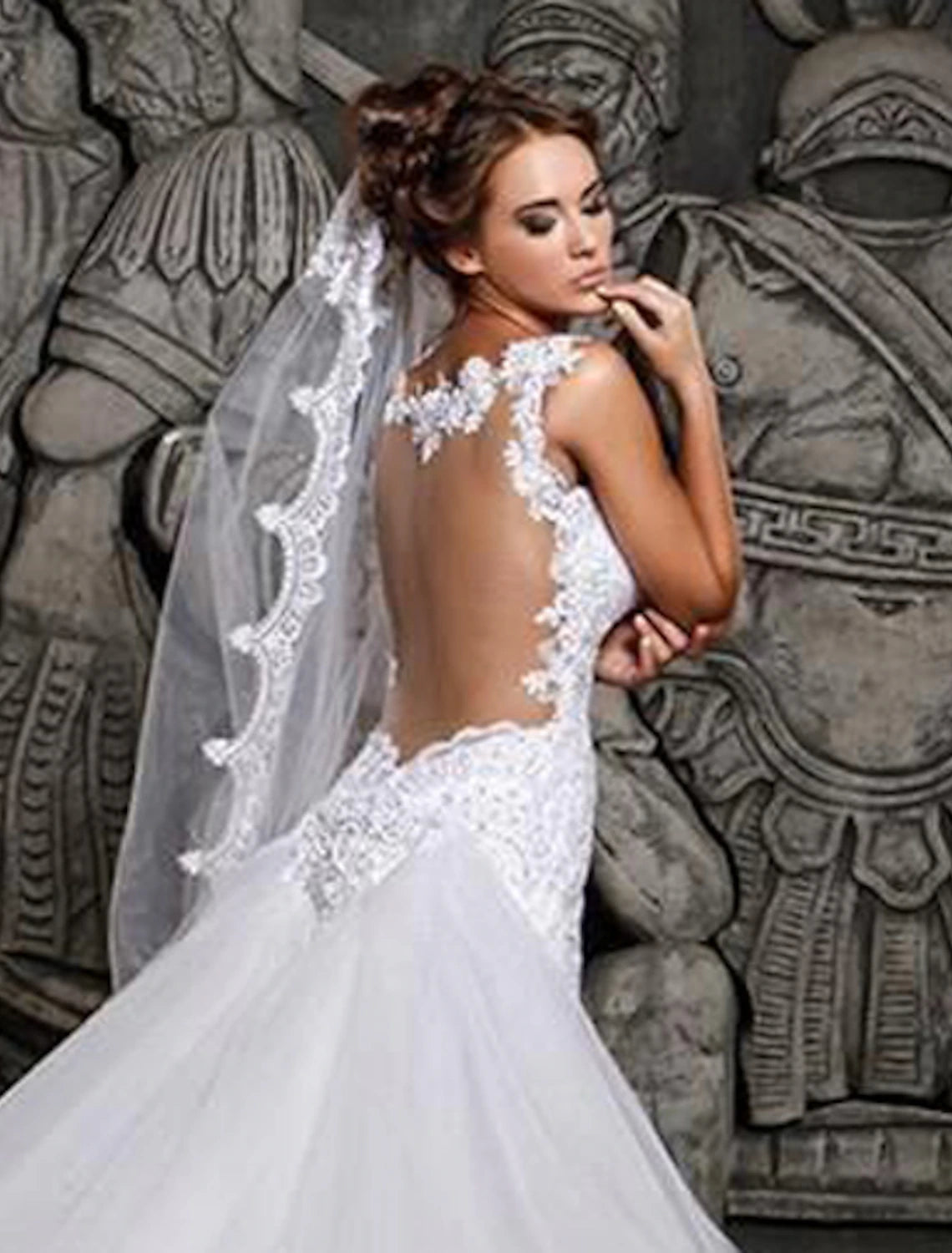 Back view of a lace mermaid wedding dress showing open back and court train.