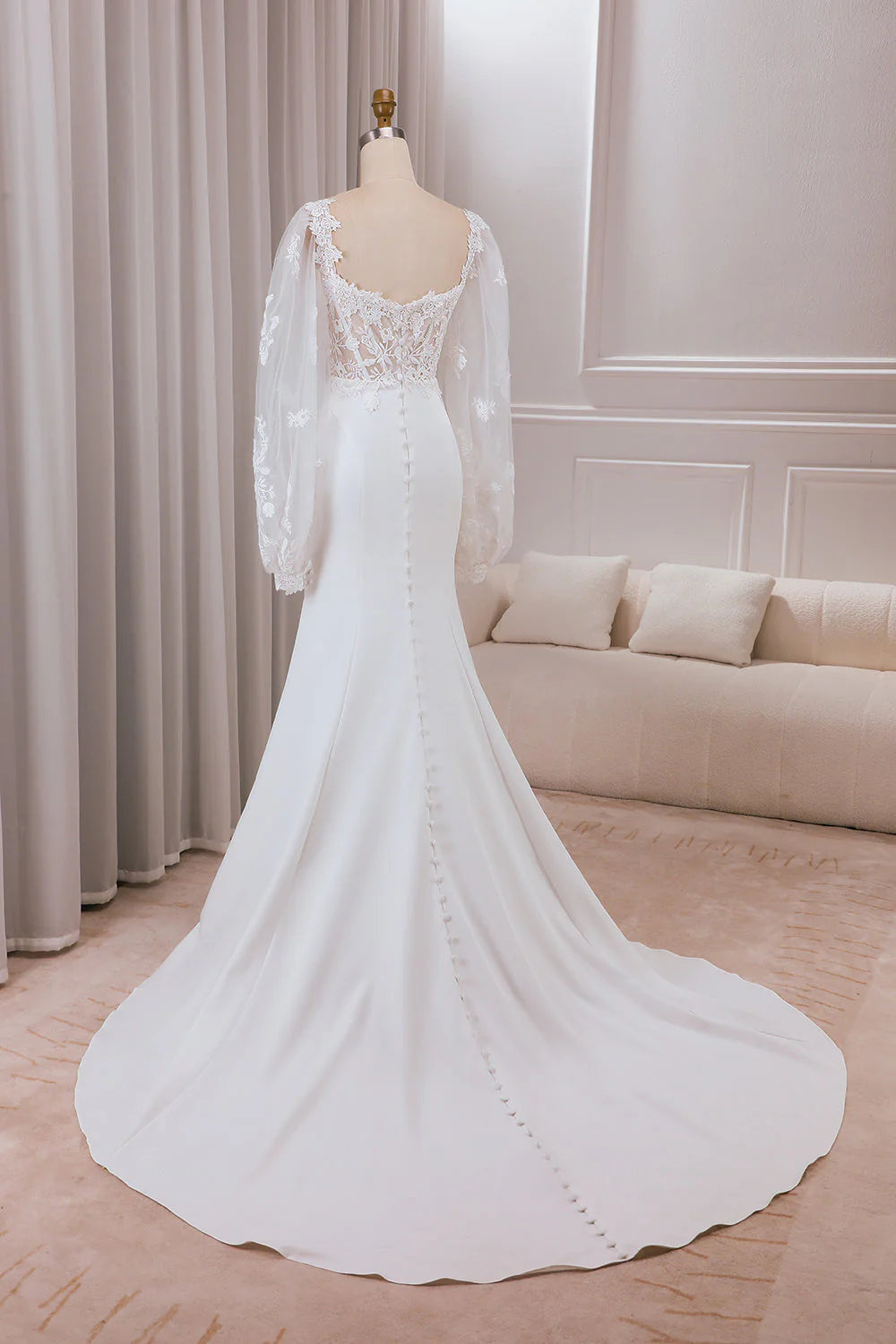 Back view of mermaid wedding dress showing sweep train and lace details.