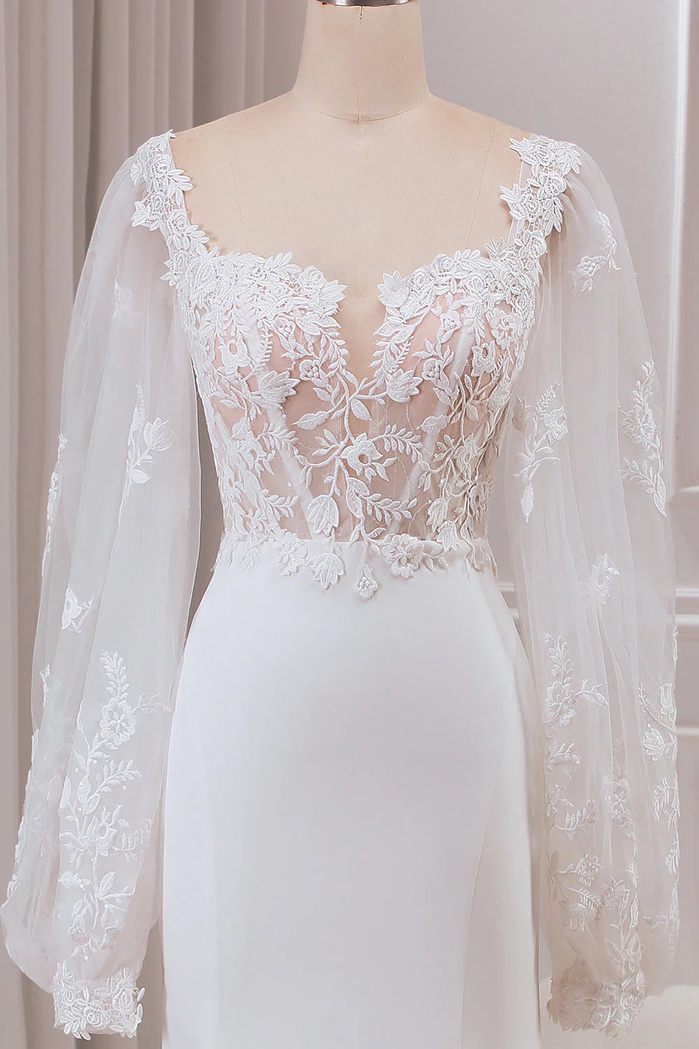 Bride wearing an ivory mermaid wedding dress with a sweep train.