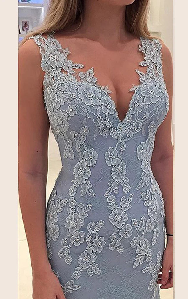 Woman posing in a long formal mermaid gown with thin straps.