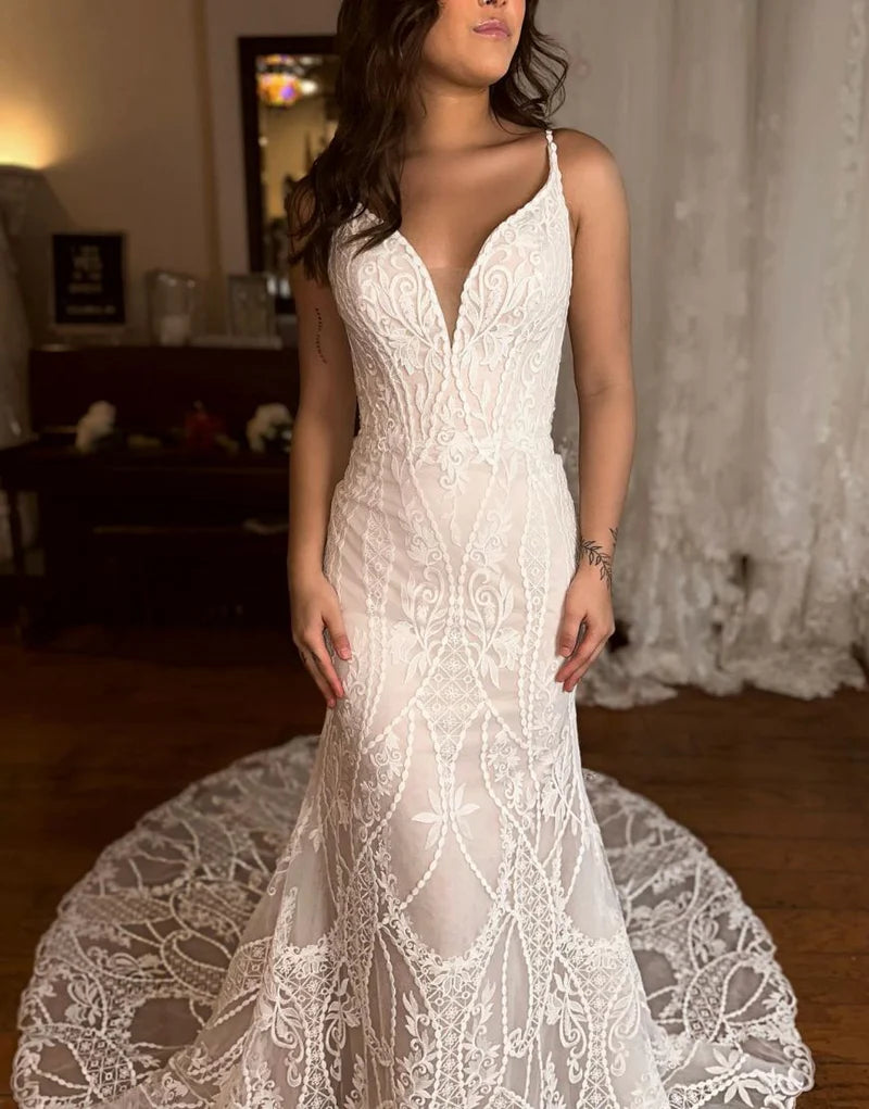 Front view of an elegant mermaid wedding dress with a V-neck and spaghetti straps.
