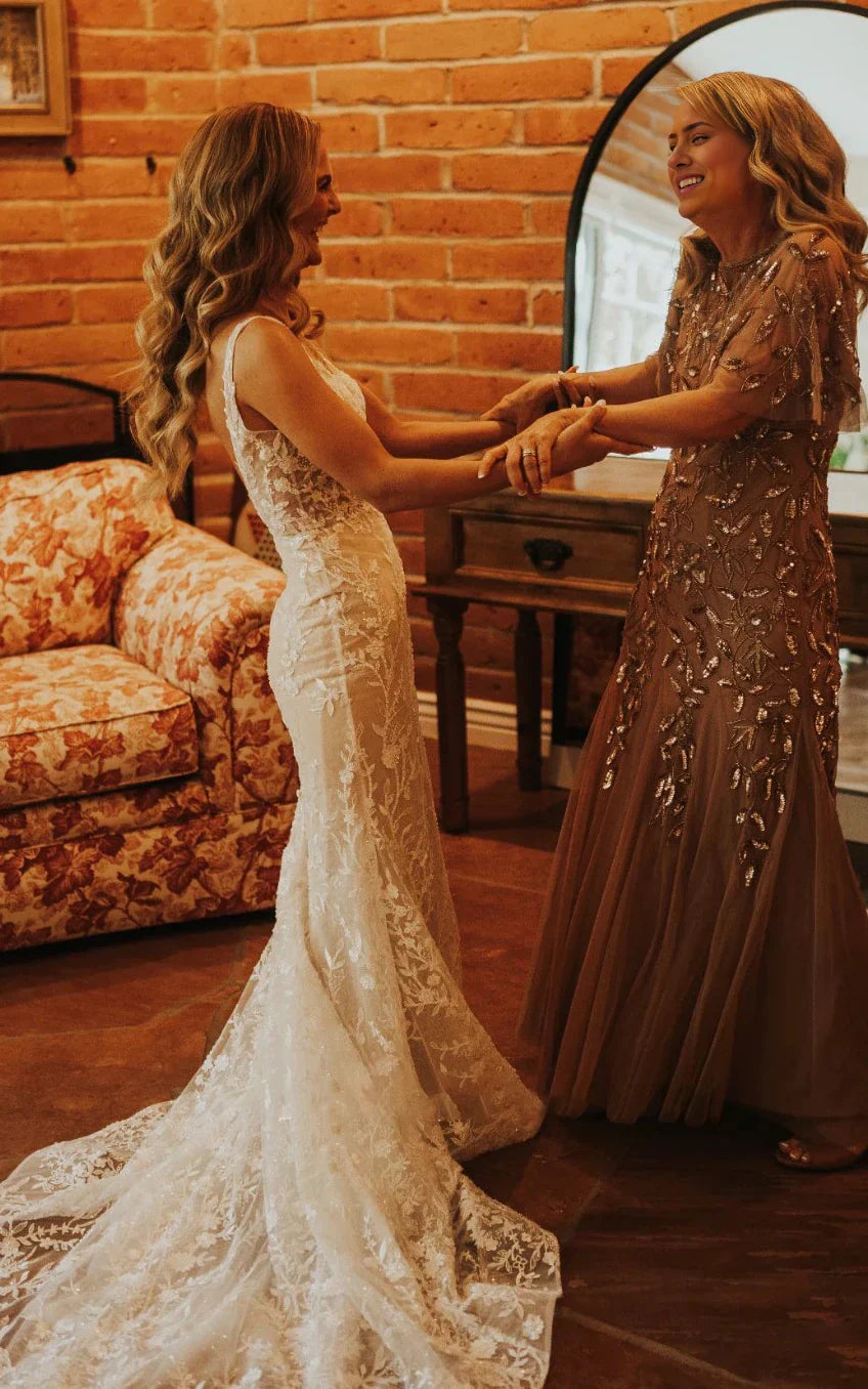 Full-length view of an elegant lace mermaid V-neck wedding dress with a sweep train.