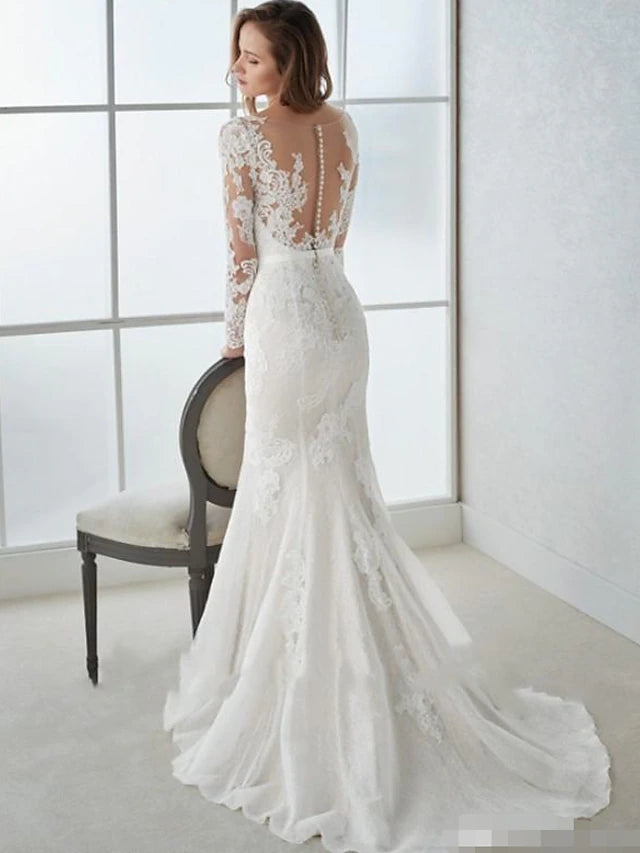 Close-up of the intricate lace detail and sweep train on the wedding dress.