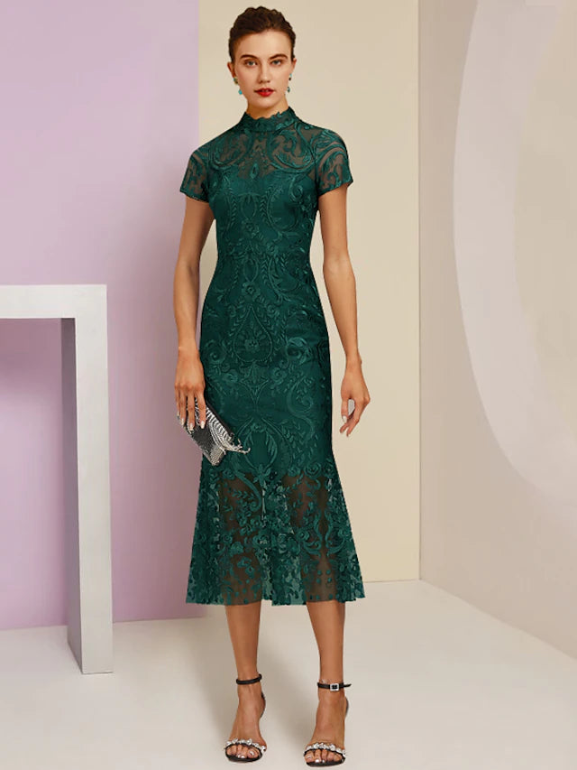 Elegant woman wearing a high neck, short sleeve, tea length lace sheath dress with appliques.