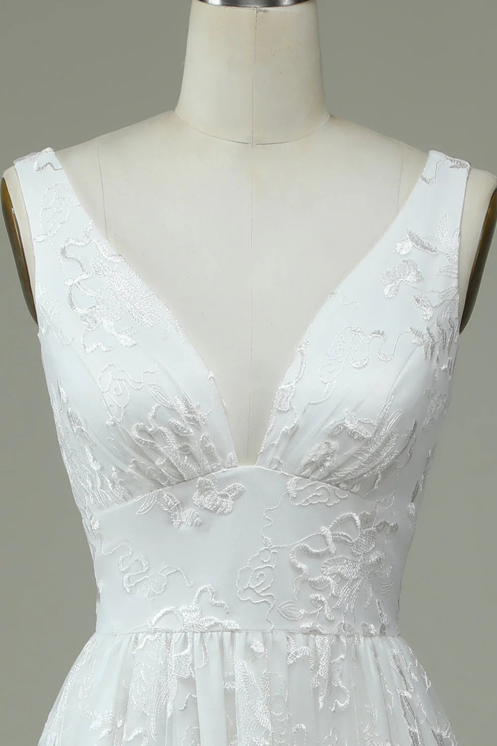 Close-up of the lace V-neckline and slit on a wedding dress.