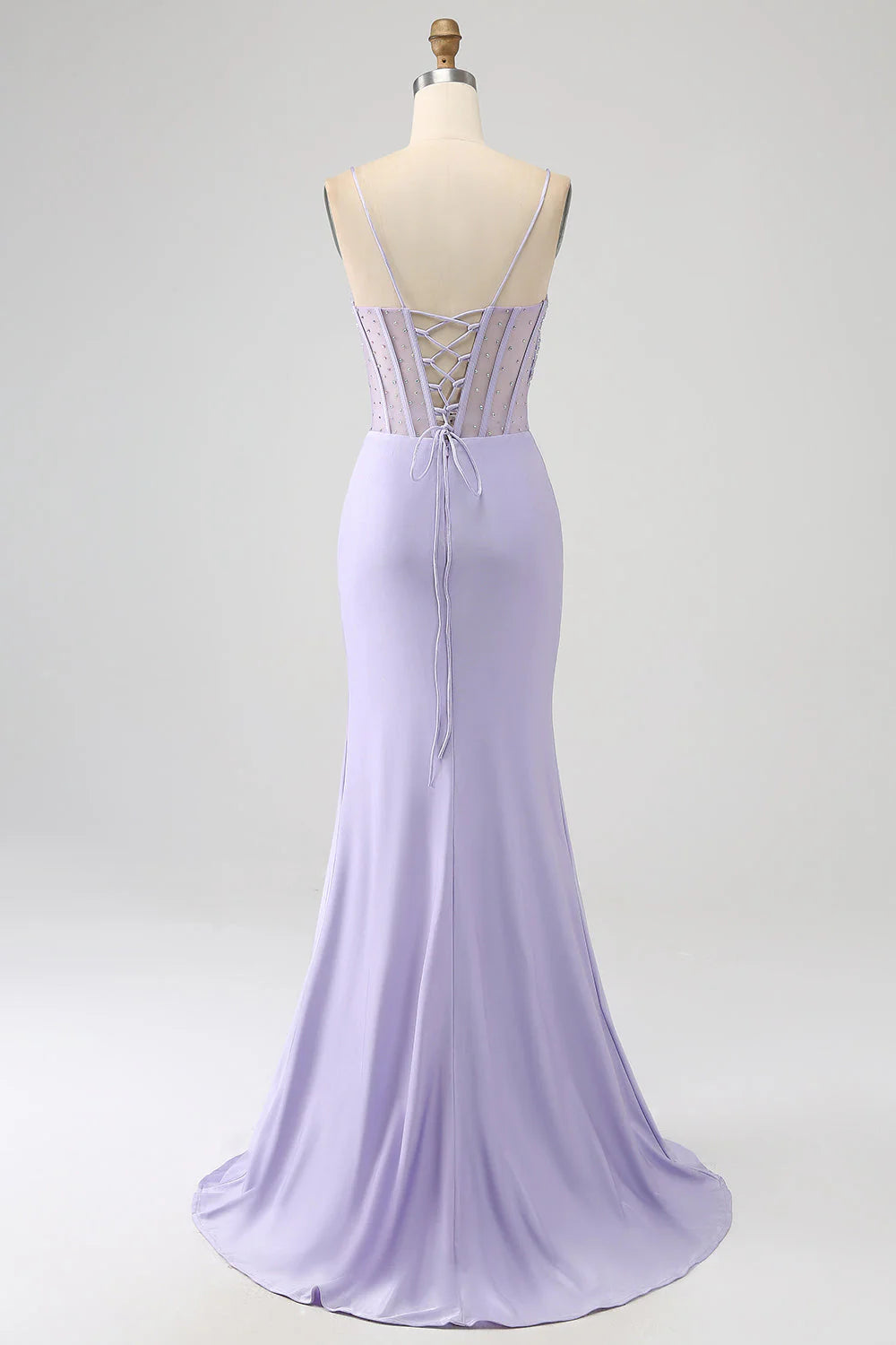 Side view of a woman wearing a lavender mermaid formal gown.