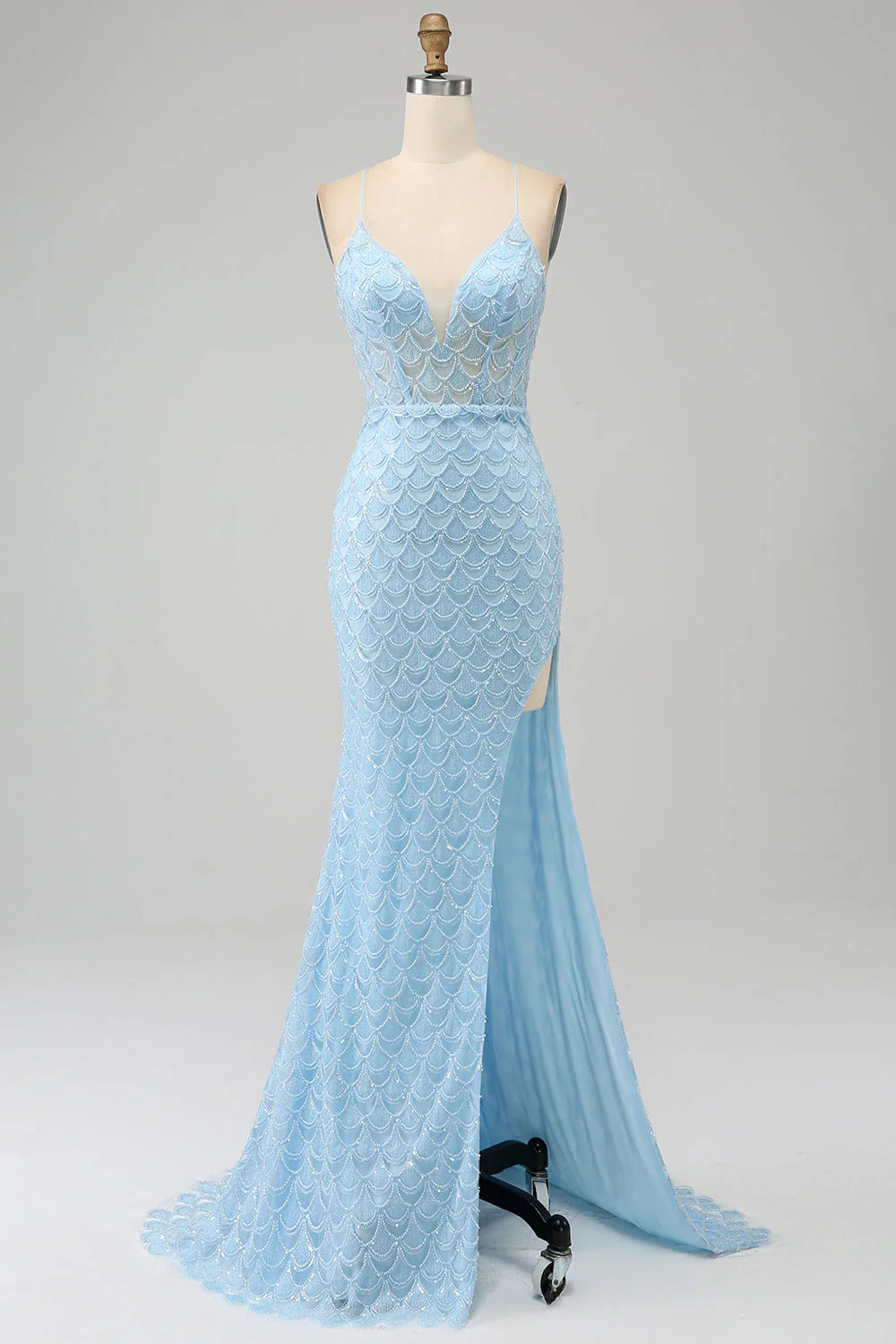 Model wearing a light blue mermaid prom dress with a high slit.