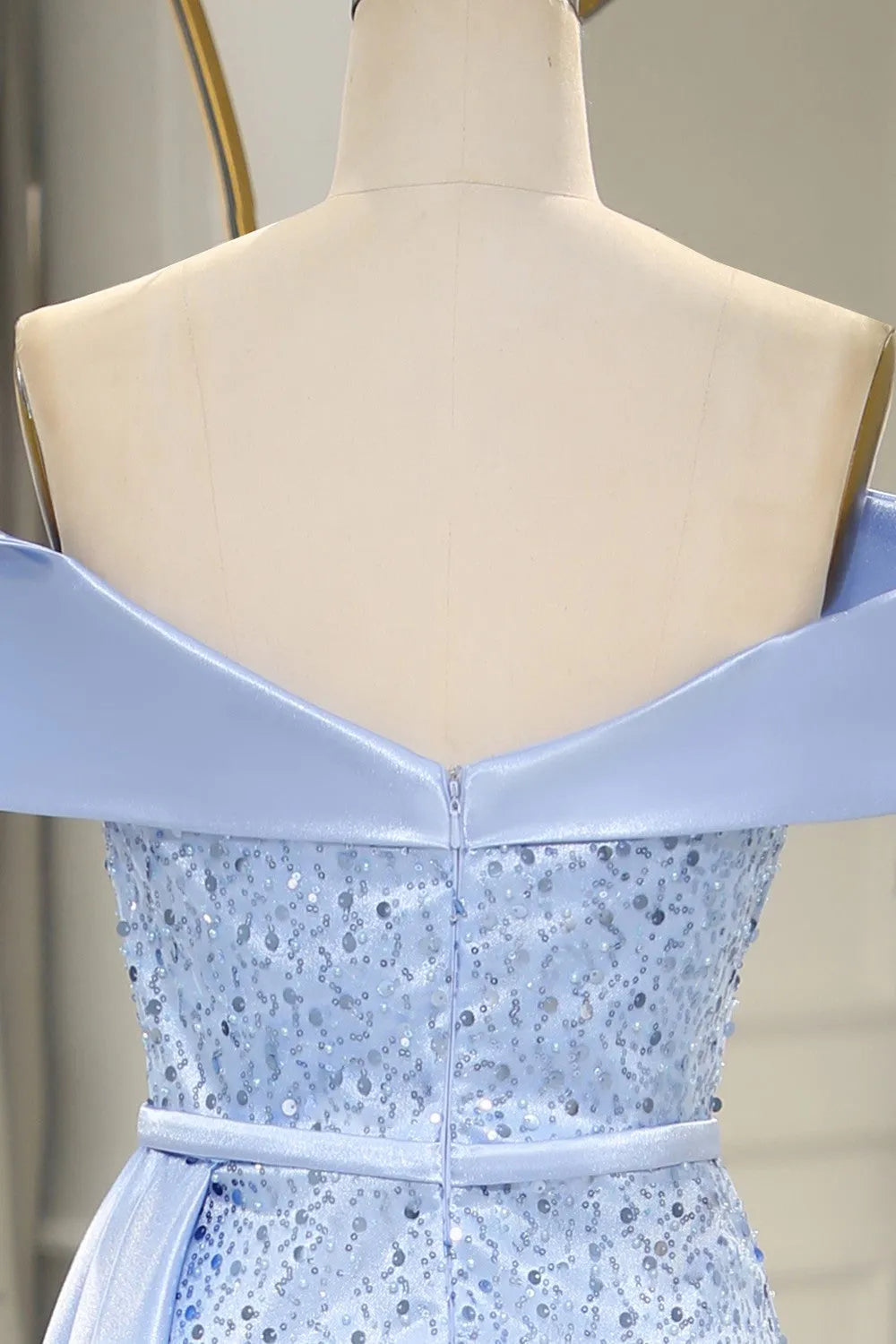 Model posing in a light blue mermaid prom dress, showcasing the split.