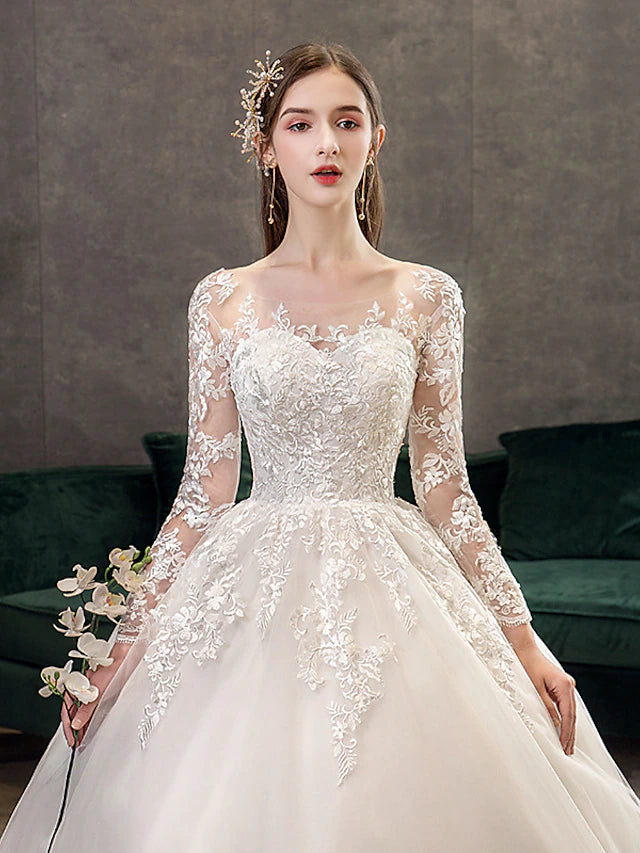 Back view of a wedding dress showing cathedral train and lace details.
