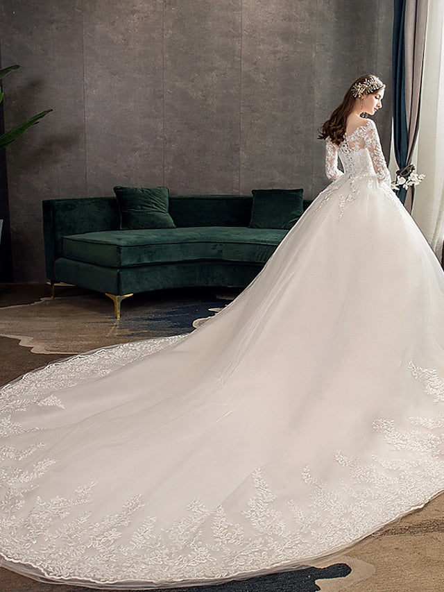 Bride posing in a white ball gown with a long, flowing train.