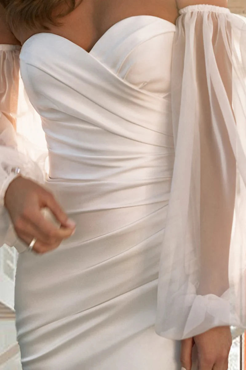 Side profile of a bride wearing a long sleeve mermaid trumpet wedding dress.