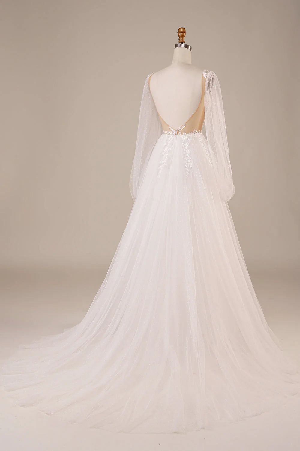 Back view of ivory wedding dress showcasing open back and lace appliques.