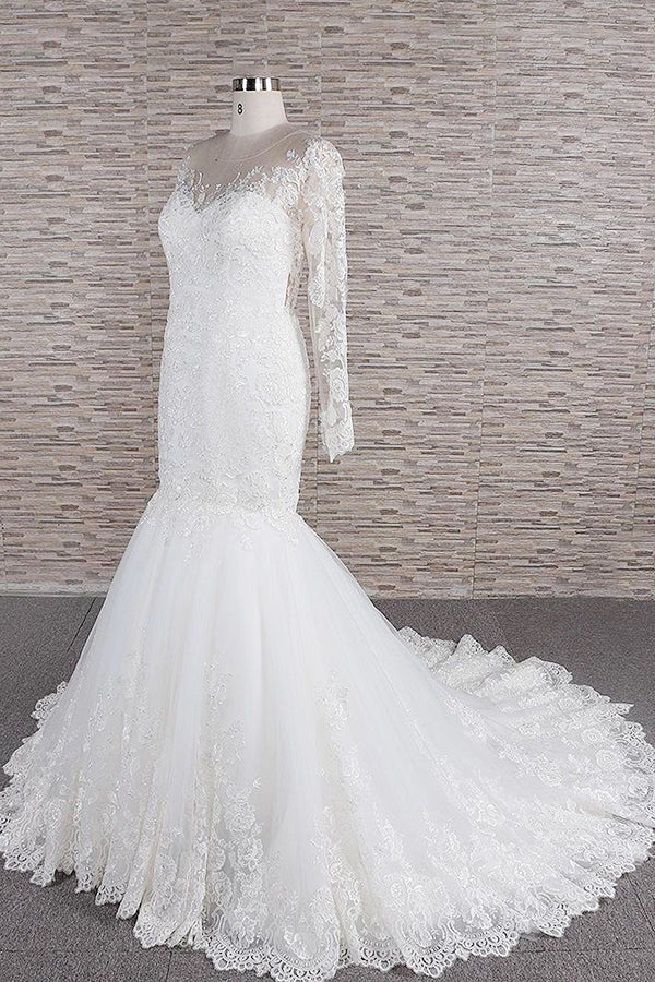 Full length view of the long sleeve lace wedding dress with a flowing silhouette.